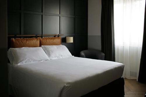 a bedroom with a large white bed and a window at c-hotels Club House Roma in Rome