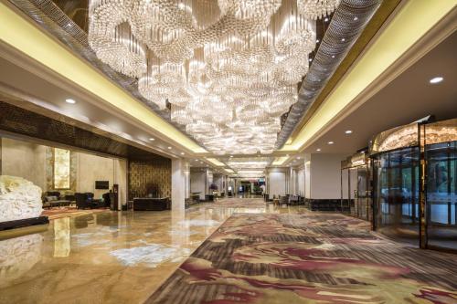 a large lobby with a chandelier and a large rug at JinJiang International Hotel Urumqi in Ürümqi