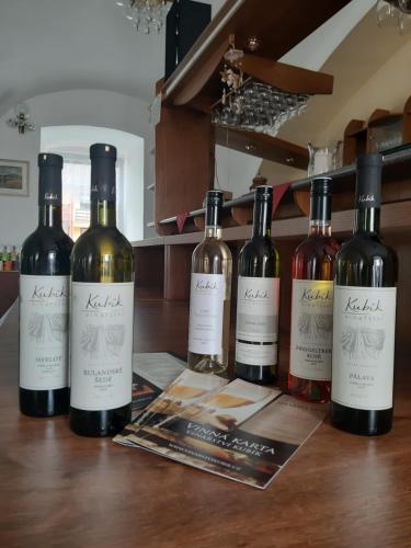 four bottles of wine sitting on a table at Hotel Jestřábí in Černá v Pošumaví