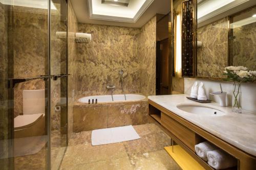 W łazience znajduje się wanna, umywalka i prysznic. w obiekcie JinJiang International Hotel Urumqi w mieście Urumczi