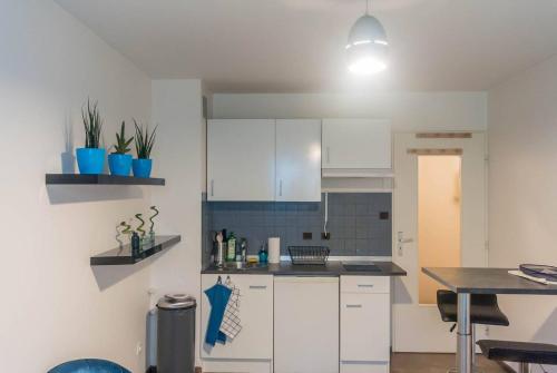 une cuisine avec des armoires blanches et une table à l'intérieur dans l'établissement Travel Homes - The Bluefel, 2m walk Little Venice, à Colmar