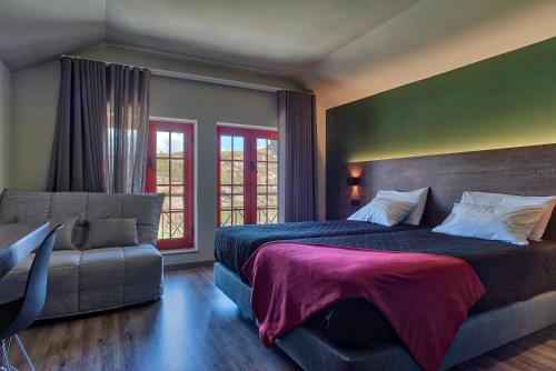 a bedroom with a large bed and a couch at Alojamento Local - Miradouro do Castelo in Castro Laboreiro
