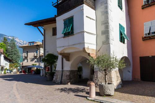 a building with a clock tower on a street at Albergo Diffuso ELA Living - Apartment Bellepoque in Egna