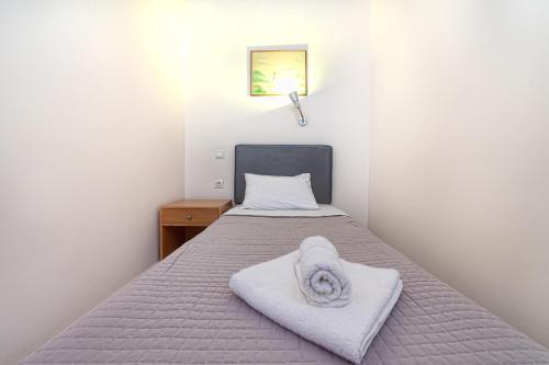 a bedroom with a bed with towels on it at Olympic Suites in Rethymno Town
