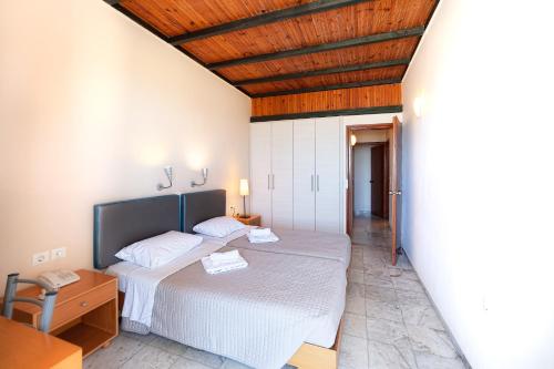 a bedroom with two beds and a wooden ceiling at Olympic Suites in Rethymno Town