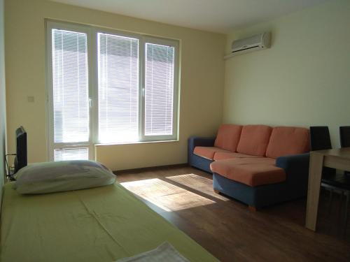 ein Wohnzimmer mit einem Sofa und einem Tisch in der Unterkunft Private apartment in Faith - Ravda in Rawda