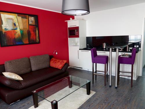 ein Wohnzimmer mit einem Sofa und einer Küche in der Unterkunft Stadthotel Langenfeld in Langenfeld