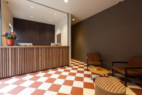 - un hall avec une réception et un sol en damier dans l'établissement Hotel Marcel, à Bruges