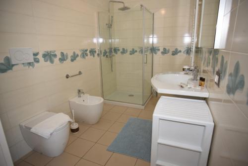 a bathroom with a toilet and a sink and a shower at MAMA BED in Porto Cesareo