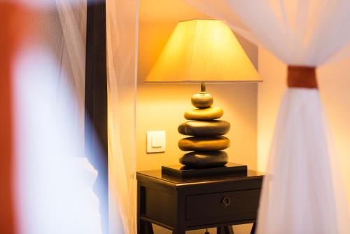 a lamp sitting on a table next to a bed at La Résidence in Dakar