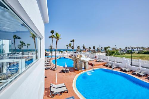托雷莫利諾斯的住宿－Ibersol Torremolinos Beach，从度假村的阳台可欣赏到游泳池和海洋的景色