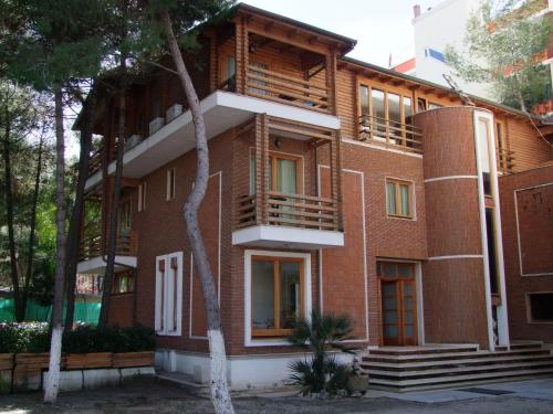 un edificio de ladrillo rojo con escaleras y ventanas en Hotel Adriatik 2, en Durrës