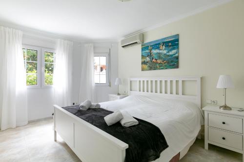 デニアにあるVilla Coralの白いベッドルーム(大型ベッド1台、窓2つ付)