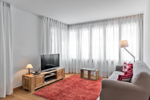 un soggiorno con divano e TV di Chesa Chalavus - St. Moritz a Sankt Moritz