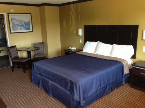 a hotel room with a large bed and a table at Del Amo Inn in Torrance