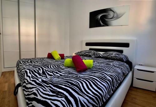 a bedroom with a zebra print bed with red and yellow pillows at Absolute Apartman in Kotor