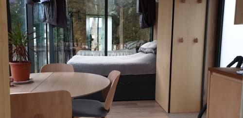 a bedroom with a bed and a table and chairs at Mirror House Roosi 21 in Pärnu