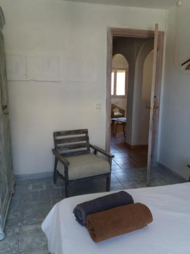 a bedroom with a bed and a chair in a room at Can Ventura in Deltebre