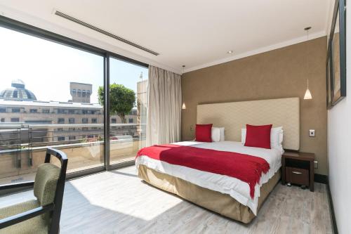 a hotel room with a bed and a large window at 207 Raphael Penthouse in Johannesburg