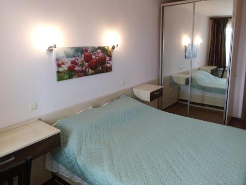 ein Hotelzimmer mit einem Bett und einem Spiegel in der Unterkunft Апартамент Зорница in Burgas City