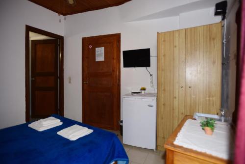 Habitación pequeña con cama azul y cocina en Stelios Rooms to Rent, en La Canea