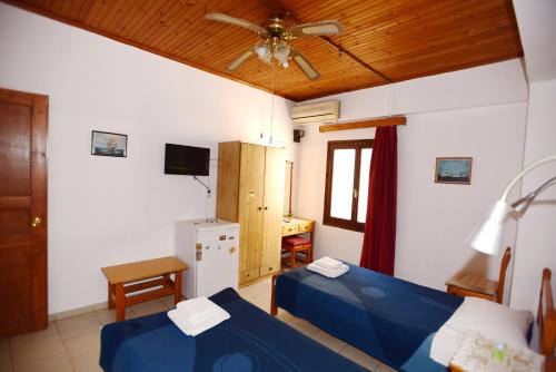 Stelios Rooms to Rent في مدينة خانيا: غرفة نوم بسريرين ومروحة سقف