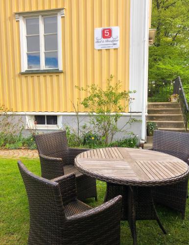 a wooden table and chairs and a table and a building at 5:ans Bed & Breakfast in Gothenburg