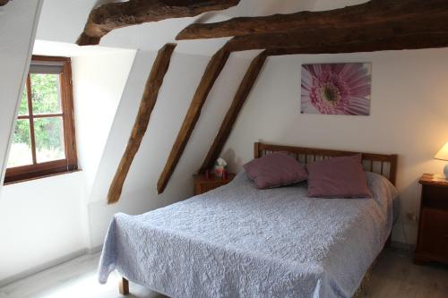 - une chambre avec un lit et des oreillers violets dans l'établissement halte aux places, à Marcillac-Saint-Quentin