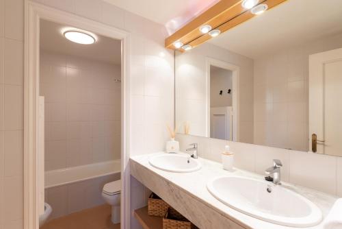 a bathroom with two sinks and a mirror at Tpa Casa en Pleta de Saga con piscina para 6/8 personas in Ger