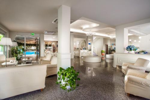 a living room with white furniture and a lobby at Hotel Sport & Residenza in Cesenatico