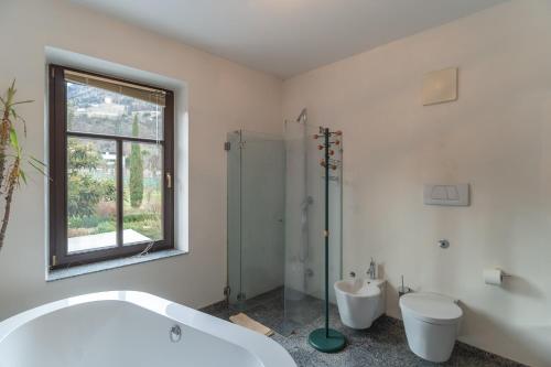 a bathroom with a tub and a toilet and a shower at Schloss-Castel Pienzenau - Guestrooms & Apartments - B&B-Hotel & Restaurant in Merano