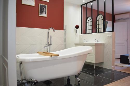 une salle de bain avec une baignoire blanche et un lavabo dans l'établissement Le Domaine Des Sources, à Saint-Martin-dʼAblois