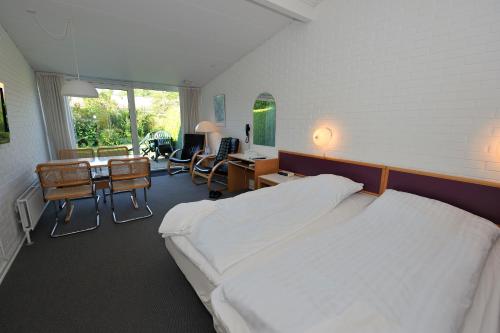 a hotel room with two beds and a desk and a desk at Hotel Balka Strand in Neksø