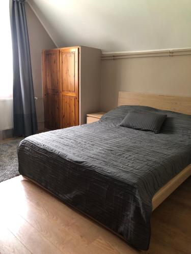 a bedroom with a large bed and a wooden cabinet at Hullám Apartman in Balatonlelle