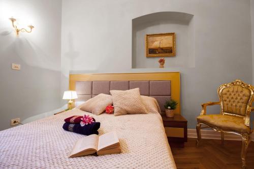 a bedroom with a bed with two books and a chair at Filip’s Palace Luxurious Apartment in Ljubljana