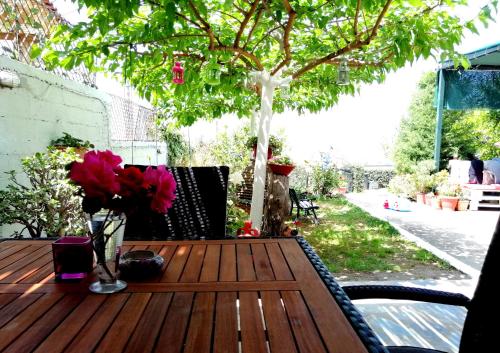 a wooden table with a vase of flowers on it at Vasiliki Guest House in Kalamata