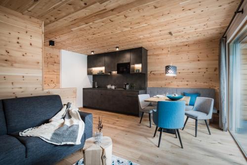 a living room with a couch and a table at Les Dolomites Mountain Lodges in San Martino in Badia