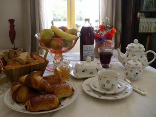 - une table avec des assiettes de pâtisseries et un bol de fruits dans l'établissement La Dentellière, à Saint-Hippolyte-le-Graveyron