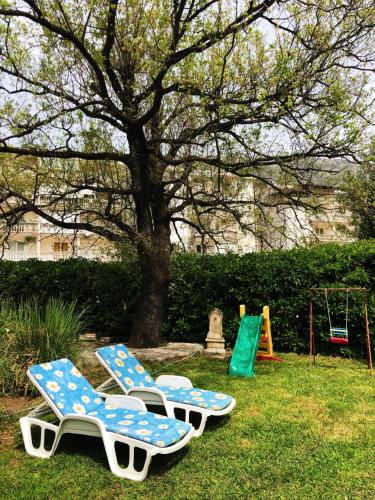 three lounge chairs and a playground in a park at Vila Jovana in Sutomore