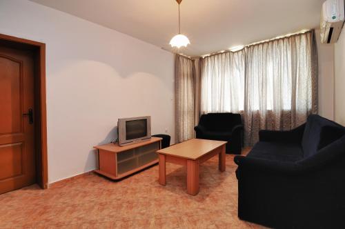 ラブダにあるPanorama Krim Beach Apartmentのリビングルーム(テレビ、ソファ、テーブル付)