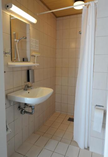 a bathroom with a sink and a shower curtain at Hotel Balka Strand in Neksø
