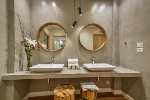 a bathroom with two sinks and two mirrors at A.P. Acropolis View Apartments in Athens