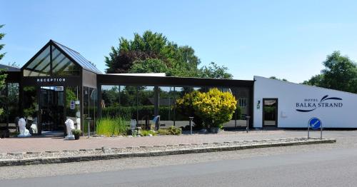 a black and white building with people in front of it at Hotel Balka Strand in Neksø