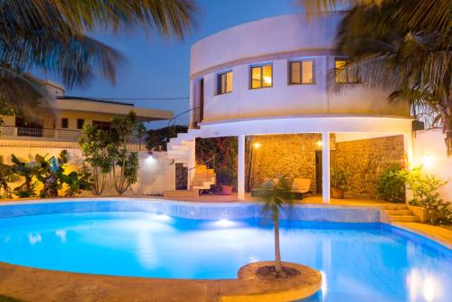 a villa with a swimming pool in front of a house at La Résidence in Dakar
