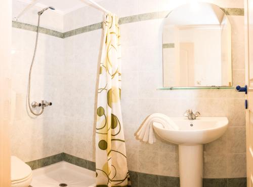 a bathroom with a sink and a shower at Uncle George Holiday Apts by Estia in Amoudara Herakliou