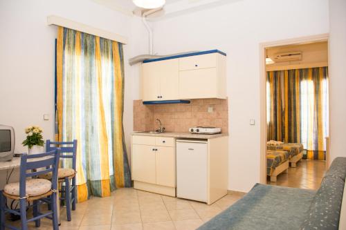 a kitchen and a living room with a table and chairs at Uncle George Holiday Apts by Estia in Amoudara Herakliou