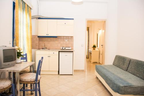 a kitchen and a living room with a couch and a table at Uncle George Holiday Apts by Estia in Amoudara Herakliou