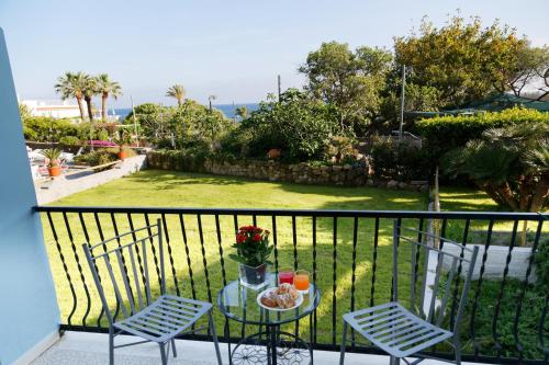a balcony with a glass table and two chairs at Hotel La Mandorla in Ischia