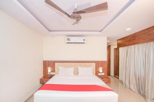 a bedroom with a bed and a ceiling fan at Hotel Blue Bell in Bengaluru