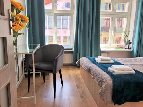 een slaapkamer met een bed, een bureau en een stoel bij Apartament na Szczytnej - free PARKING in Toruń